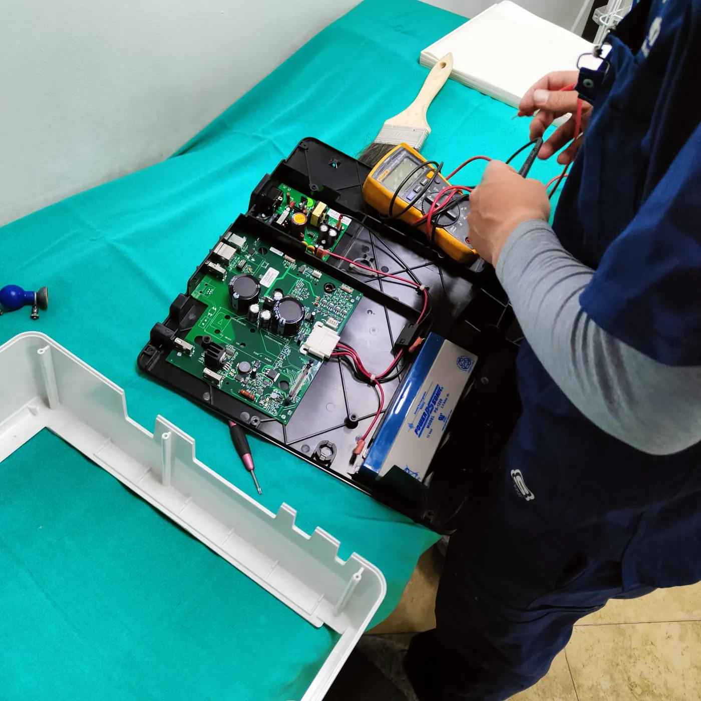 Medición con multímetro sobre la tarjeta electrónica de un equipo médico en reparación
